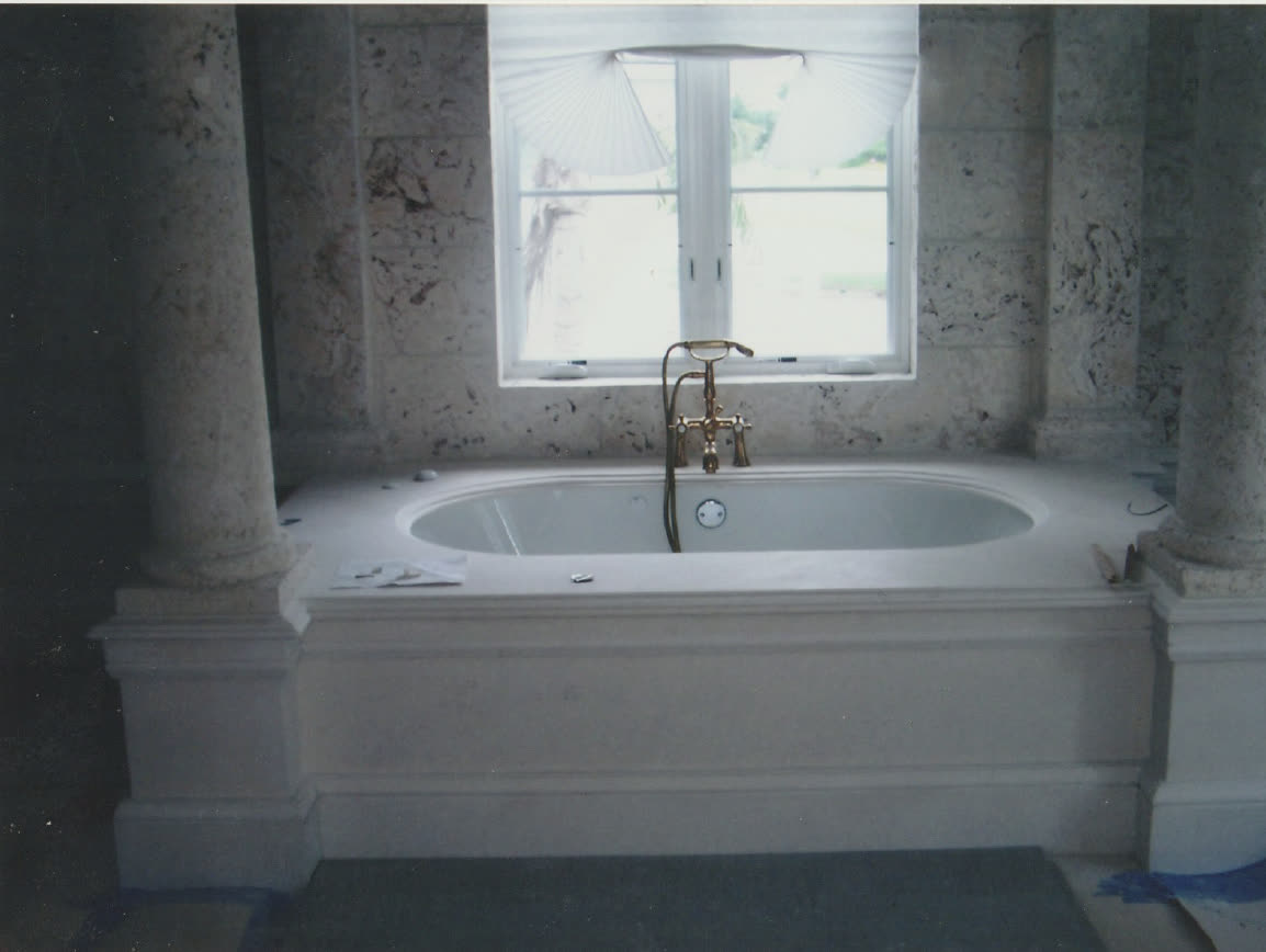 Coral stone bathroom with custom marble tub surround by Luis's Home Repairs